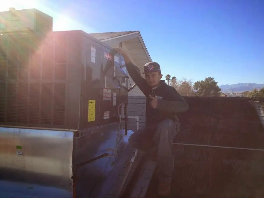 HVAC technician performing Air Duct Repair on a rooftop unit in Snyderville